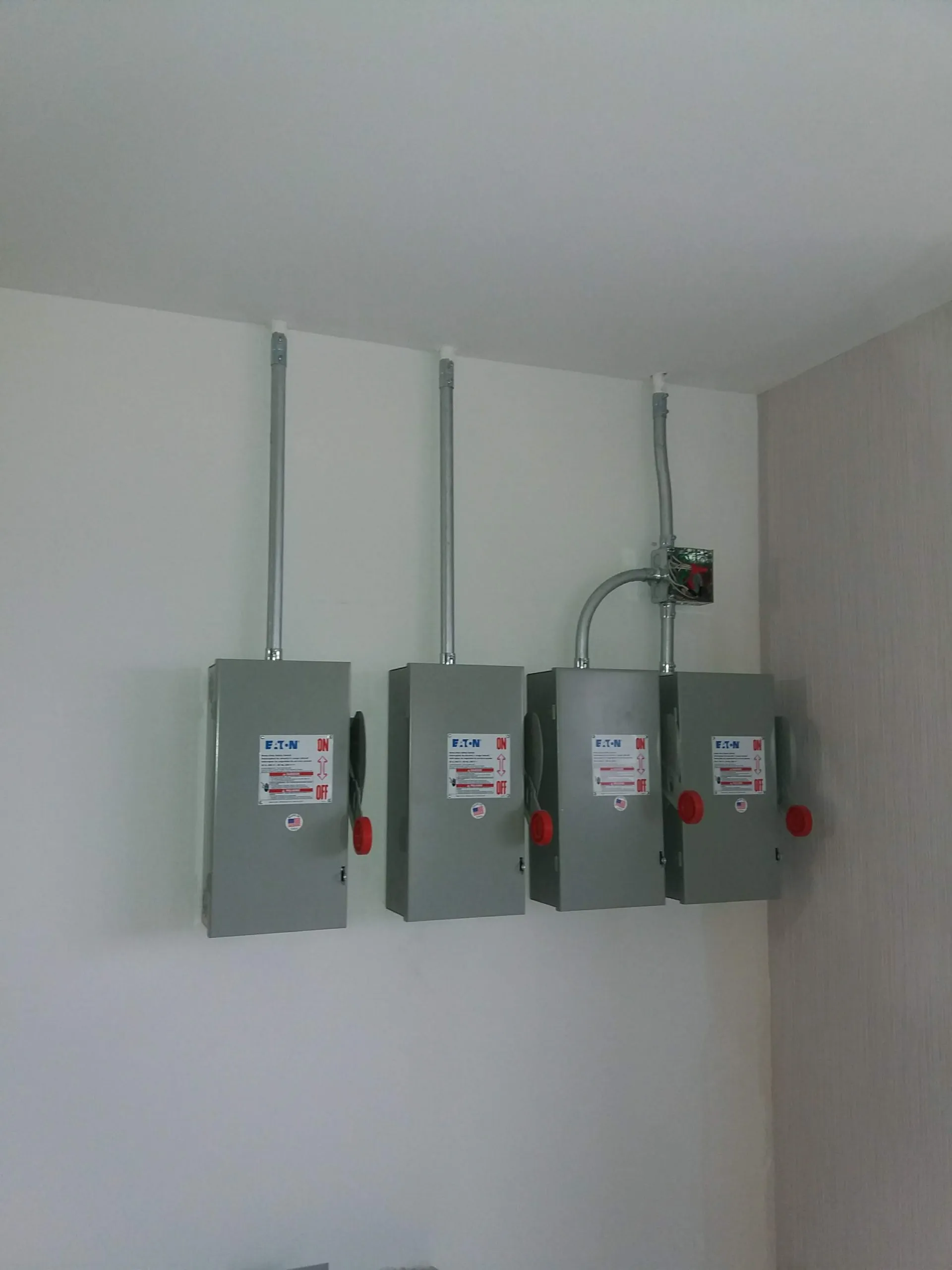 A bank of wall-mounted Eaton safety disconnects we installed